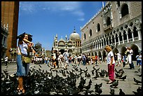 Tourists feeding  pigeons, Piazzetta San Marco (Square Saint Mark), mid-day. Venice, Veneto, Italy