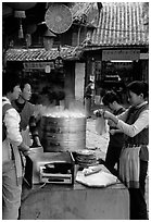 Naxi women selling dumplings and Naxi baba flatbread. Lijiang, Yunnan, China (black and white)