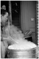Naxi Women baking dumplings. Lijiang, Yunnan, China (black and white)