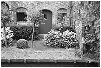 Small garden and brick house by the canal. Bruges, Belgium ( black and white)