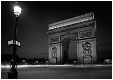 Street lamp and Etoile triumphal arch at night. Paris, France ( black and white)