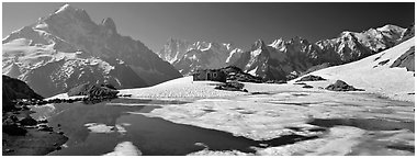High mountain landscape with partly frozen lake and Mont-Blanc Range. France (Panoramic black and white)