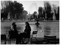 Couple sitting by basin in Tuileries Gardens. Paris, France (black and white)