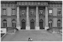 Two tourists sitting on the stairs of the Palais de Justice. Paris, France (black and white)
