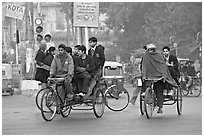 Cycle-rickshaws carrying uniformed schoolchildren. New Delhi, India ( black and white)