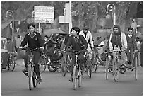 Children riding bikes in rickshaws on way to school. New Delhi, India ( black and white)