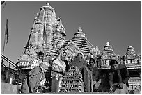 Worshippers making offering with Lakshmana temple behind. Khajuraho, Madhya Pradesh, India ( black and white)