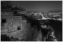 Rampart wall and city lights, Suwon Hwaseong Fortress. South Korea (black and white)