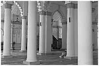 Man in prayer inside Masjid Kapitan Keling mosque. George Town, Penang, Malaysia (black and white)