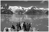 People looking at glaciers as boat crosses ice-chocked waters, Northwestern Fjord. Kenai Fjords National Park, Alaska, USA. (black and white)