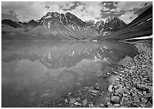 Shore of Turqouise Lake with Telaquana Mountains reflected in silty water. Lake Clark National Park ( black and white)