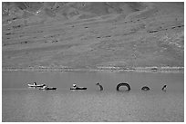 Kayakers approaching the dragon in the rare Manly Lake. Death Valley National Park, California, USA. (black and white)