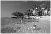 Children on Puu Poa Beach and Princeville Hotel. Kauai island, Hawaii, USA (black and white)