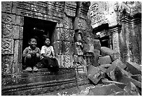 Boy and girl sit at window in Ta Prom. Angkor, Cambodia (black and white)