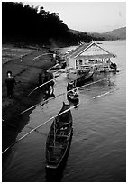 Boats and stilt house of a small hamlet. Mekong river, Laos (black and white)