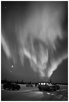 Northern Lights dance above snowy parking lot. Alaska, USA (black and white)