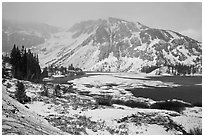Partly frozen Ellery Lake and mountains with snow. California, USA ( black and white)