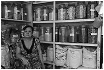 Woman with jars of traditional medicinal supplies. Cholon, Ho Chi Minh City, Vietnam (black and white)