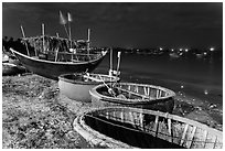 Coracle boats and fishing fleet at night. Mui Ne, Vietnam (black and white)