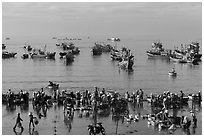 View from above of fishermen, vendors, and fishing fleet. Mui Ne, Vietnam (black and white)