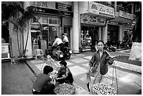 Old and new: street fruit vendors and computer store. Ho Chi Minh City, Vietnam (black and white)