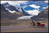 Cyclists on the Icefields Parkway in front of the Athabasca Glacier. Jasper National Park, Canadian Rockies, Alberta, Canada (color)