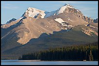 Canoe dwarfed by the Mt Charlton and Mt Unwin surrounding Maligne Lake. Jasper National Park, Canadian Rockies, Alberta, Canada