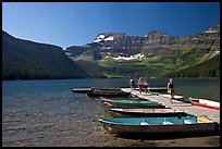 Dock and small boats, with tourists walking down, Cameron Lake. Waterton Lakes National Park, Alberta, Canada ( color)