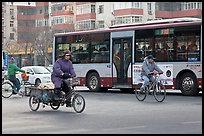Tricyle, bicycles and bus on street. Beijing, China (color)