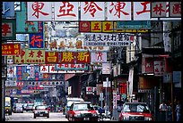 Taxicabs in a street filled up with signs in Chinese, Kowloon. Hong-Kong, China