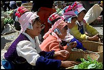 Bai women in tribal dress selling vegetables at the Monday market. Shaping, Yunnan, China (color)