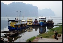 Boats along the river with misty cliffs in the background. Leshan, Sichuan, China (color)