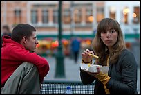 Young woman eating fries, Markt. Bruges, Belgium (color)