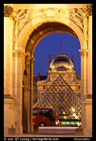 Louvre, pyramid, and bus seen through the Carousel Arch at night. Paris, France