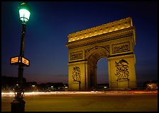Street lamp and Etoile triumphal arch at night. Paris, France