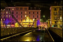 Pedestrians on suspension bridge at night. Grenoble, France (color)