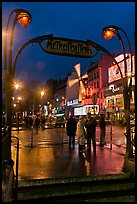 Art deco subway entrance and Moulin Rouge by night. Paris, France (color)