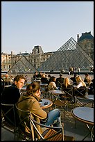Couple sitting on terrace in Louvre main courtyard. Paris, France