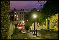 Hillside stairs of butte Montmartre and street lights at sunset. Paris, France