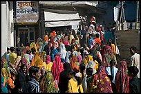 Street with women in colorful sari following wedding procession. Jodhpur, Rajasthan, India (color)