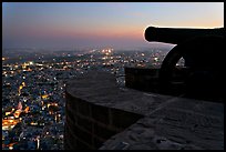 Cannon on top of Mehrangarh Fort, and city lights below. Jodhpur, Rajasthan, India (color)