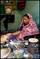 Woman with headscarf stacking chapati bread. Jodhpur, Rajasthan, India (color)