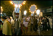 Men carrying bright electric signs during wedding procession. Varanasi, Uttar Pradesh, India (color)