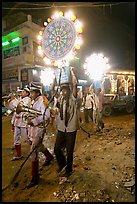Uniformed musicians and men carrying lights during wedding procession. Varanasi, Uttar Pradesh, India (color)