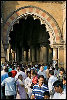 Crowd pass beneath an archway, Chhatrapati Shivaji Terminus. Mumbai, Maharashtra, India