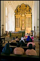 Indian women sitting in front of the altar, Basilica of Bom Jesus, Old Goa. Goa, India