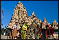 Worshippers making offering with Lakshmana temple behind. Khajuraho, Madhya Pradesh, India ( color)
