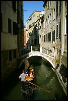 Gondola tour in a picturesque canal with bridge. Venice, Veneto, Italy (color)