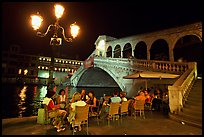 Outdoor cafe terrace,  Rialto Bridge at night. Venice, Veneto, Italy (color)