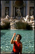 Tourist tosses a coin over her shoulder in the Trevi Fountain. Rome, Lazio, Italy ( color)